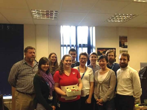 Ali with birthday cupcakes and team
