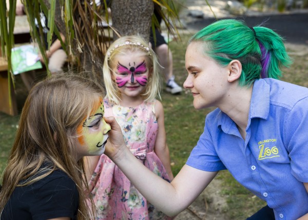 Zoo staff member face painting guests